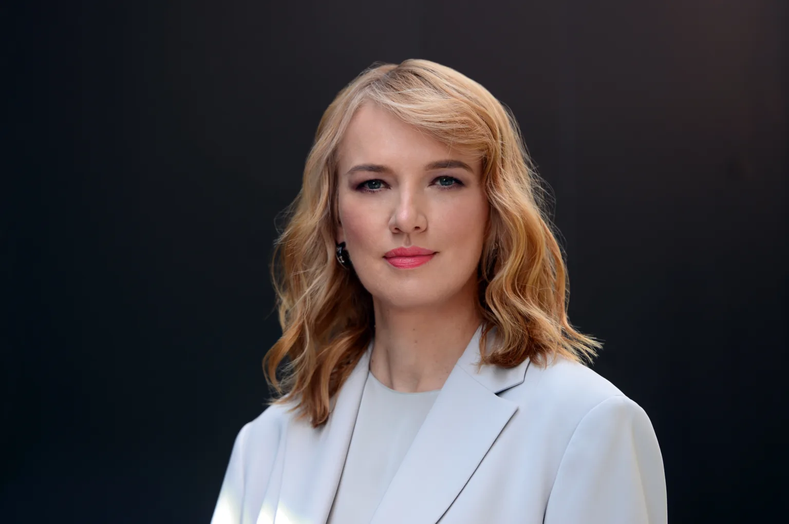 Жінка в діловому костюмі на темному тлі