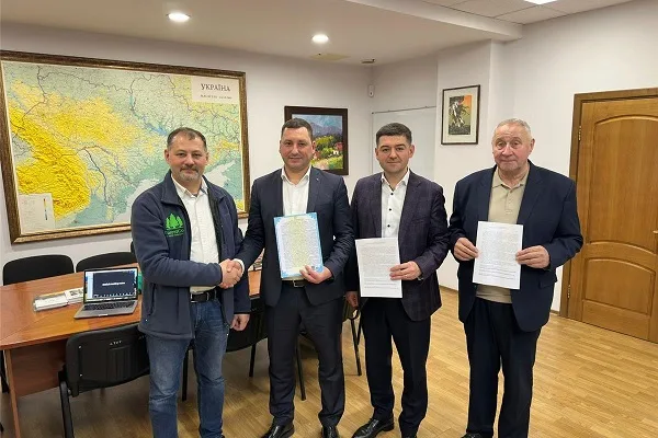 Чотири чоловіки підписують офіційні документи в офісі