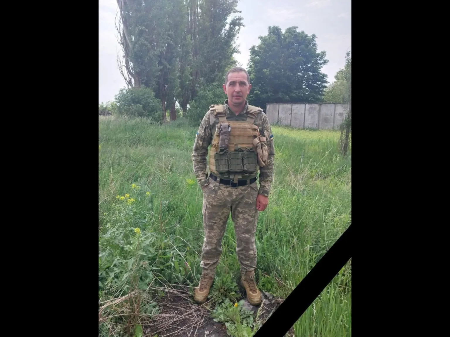 Військовий у камуфляжі стоїть на трав'яному полі