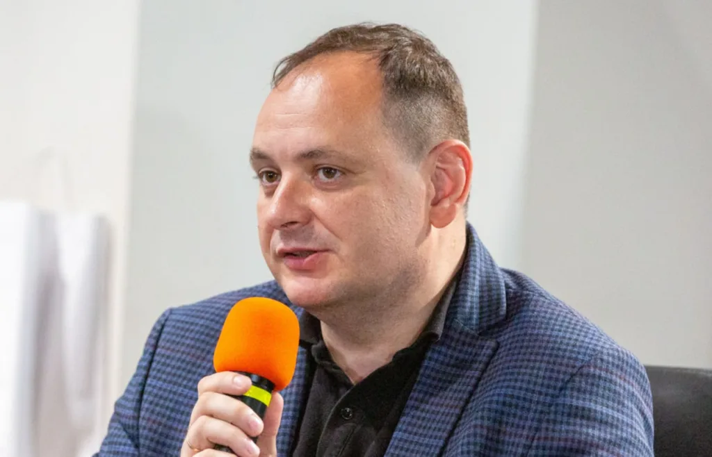 Чоловік говорить у мікрофон під час виступу