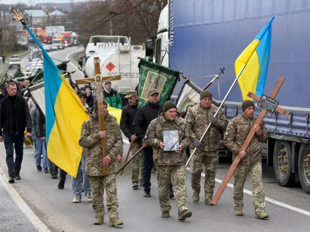 Військові з українськими прапорами на похоронній процесії