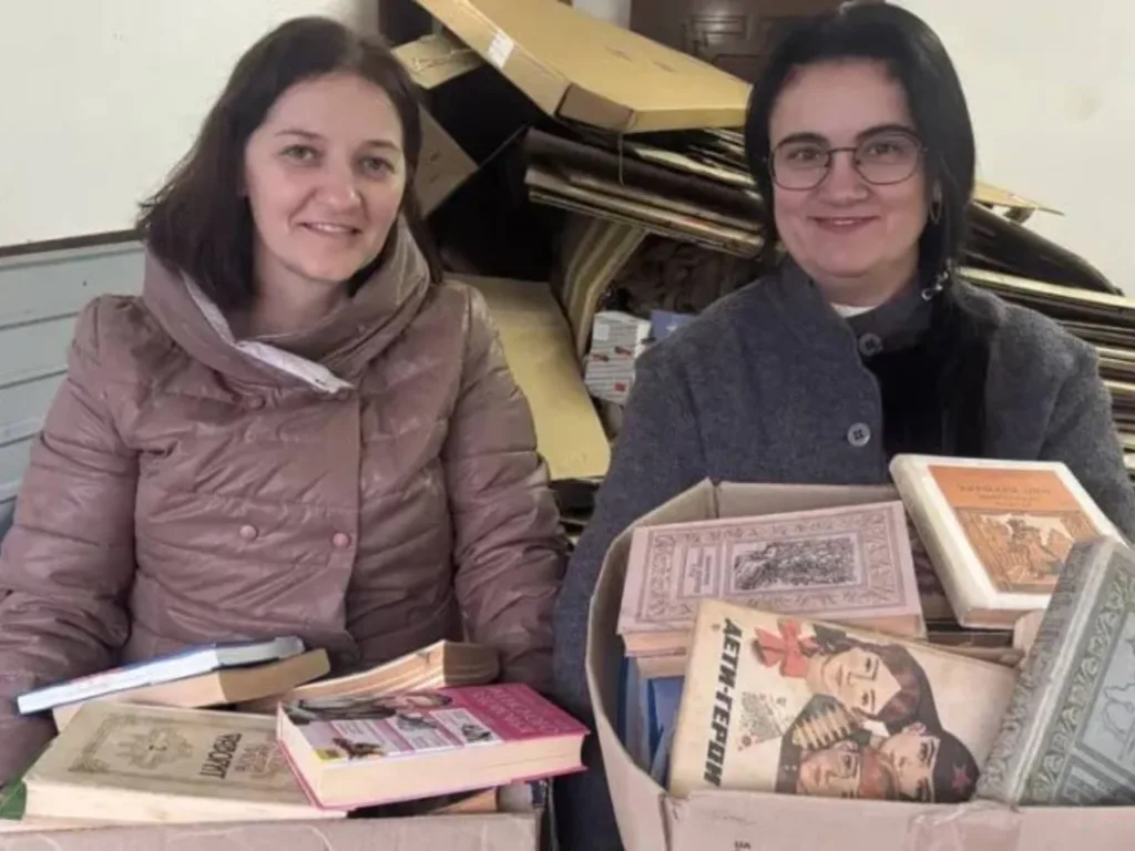 Дві жінки тримають коробки з книгами