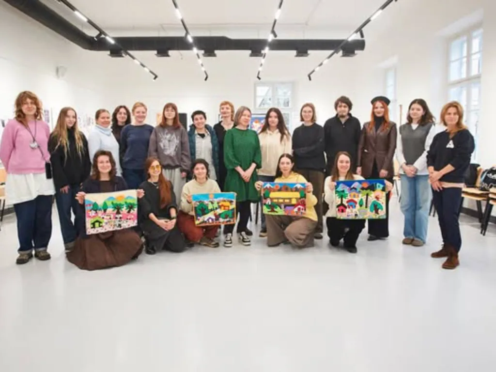 Група людей із яскравими картинами у галереї