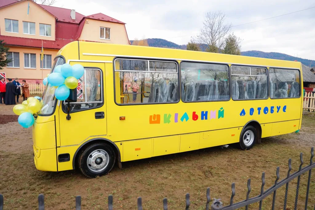 Жовтий шкільний автобус біля школи