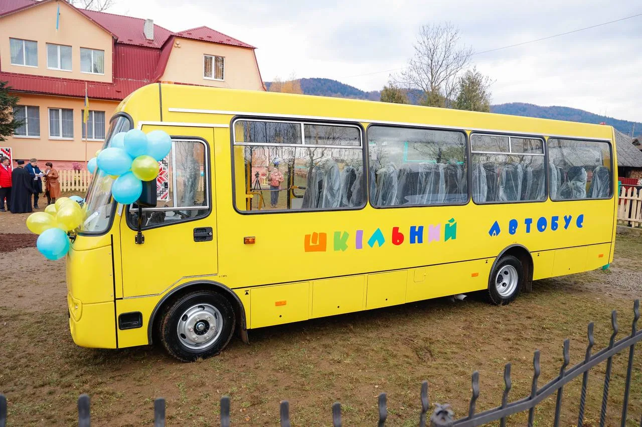 Жовтий шкільний автобус біля школи
