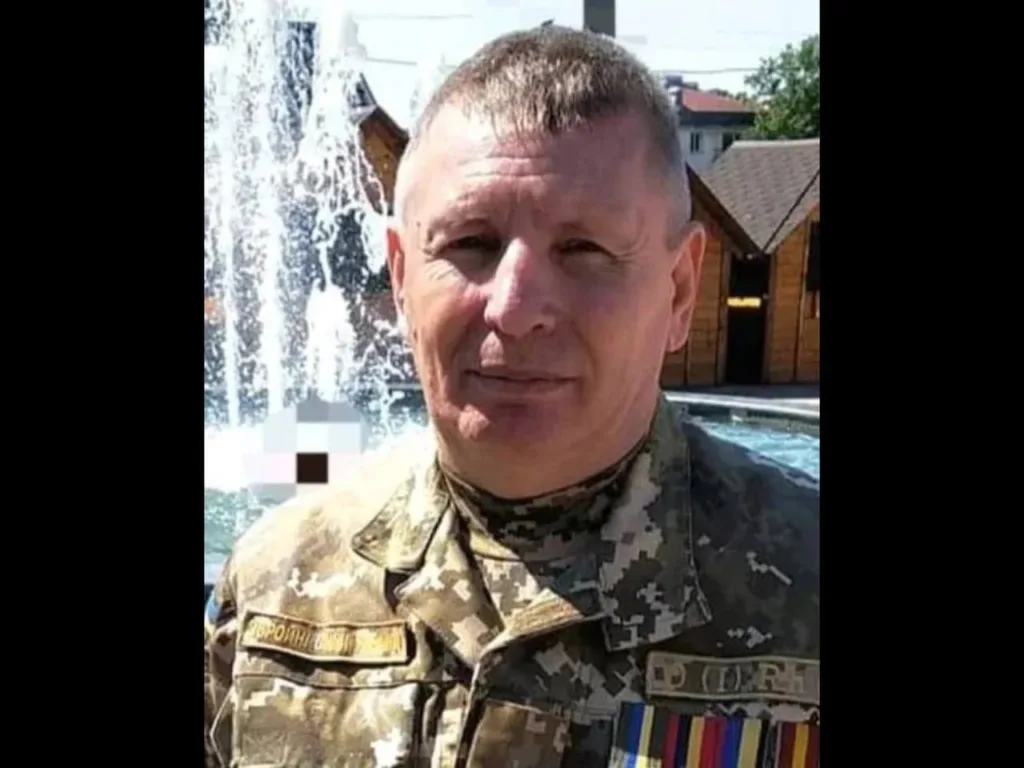 Український військовий у формі перед фонтаном