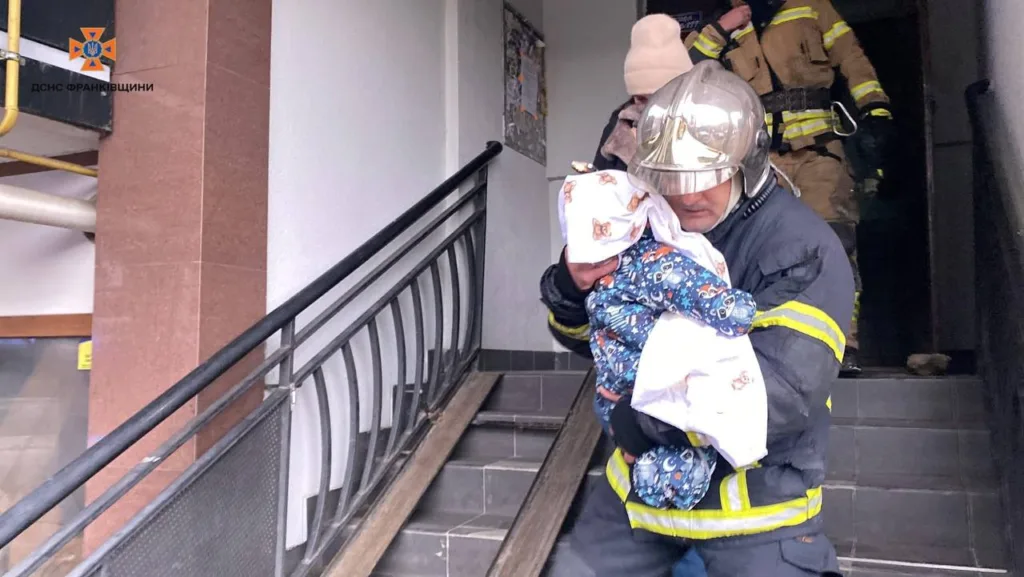 Рятувальник несе дитину під час евакуації