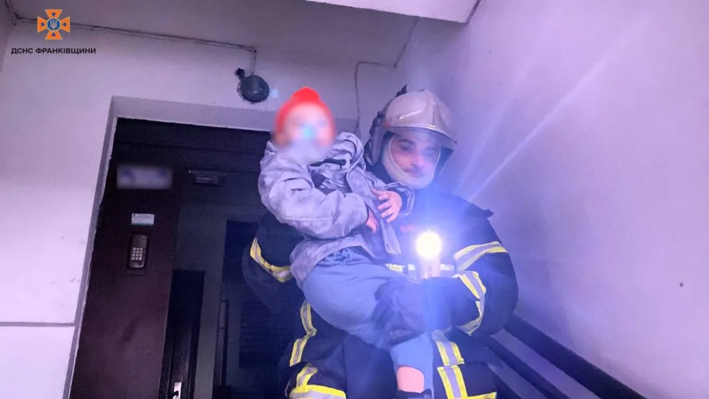 Рятувальник несе дитину сходами під час порятунку