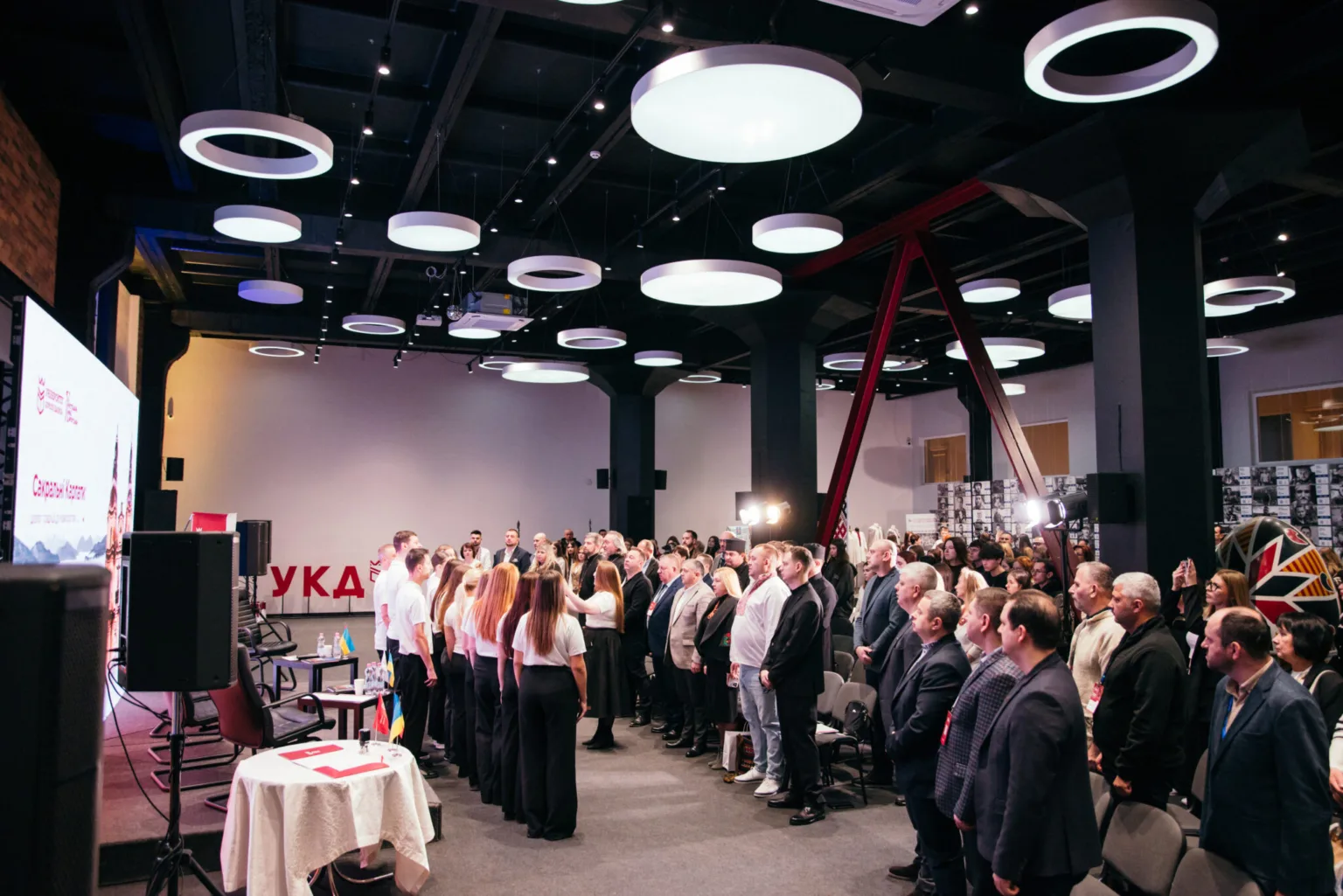 Люди стоять на офіційній події в конференц-залі