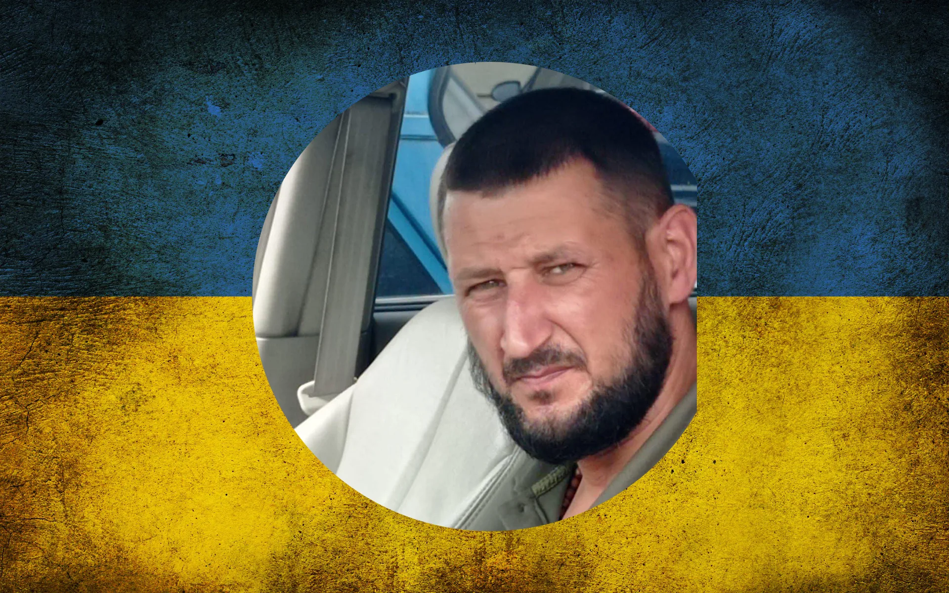 Чоловік у машині на тлі прапора України