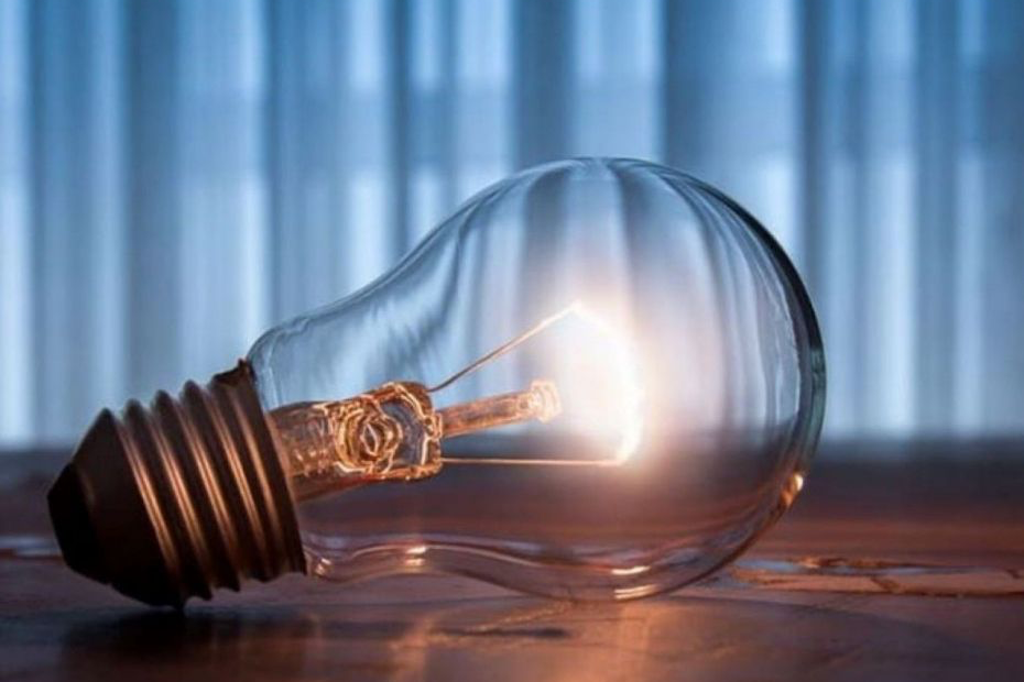 Освітлена лампочка лежить на дерев'яній поверхні