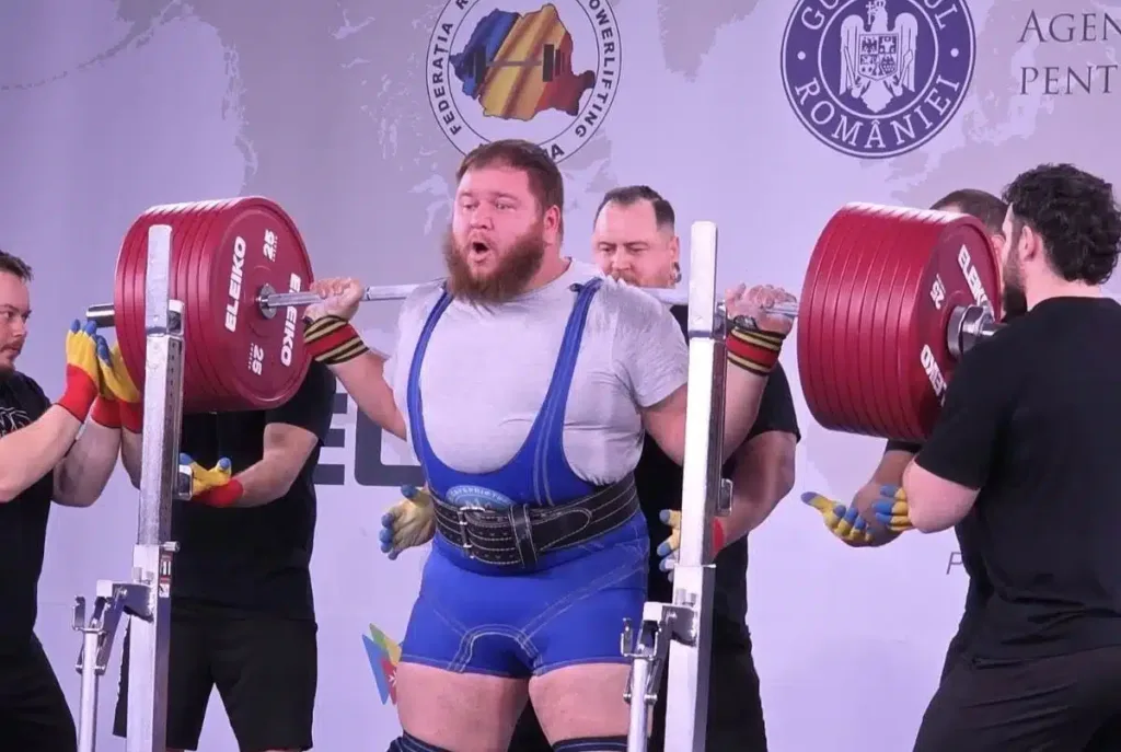 Пауерліфтер виконує присідання з важкою штангою