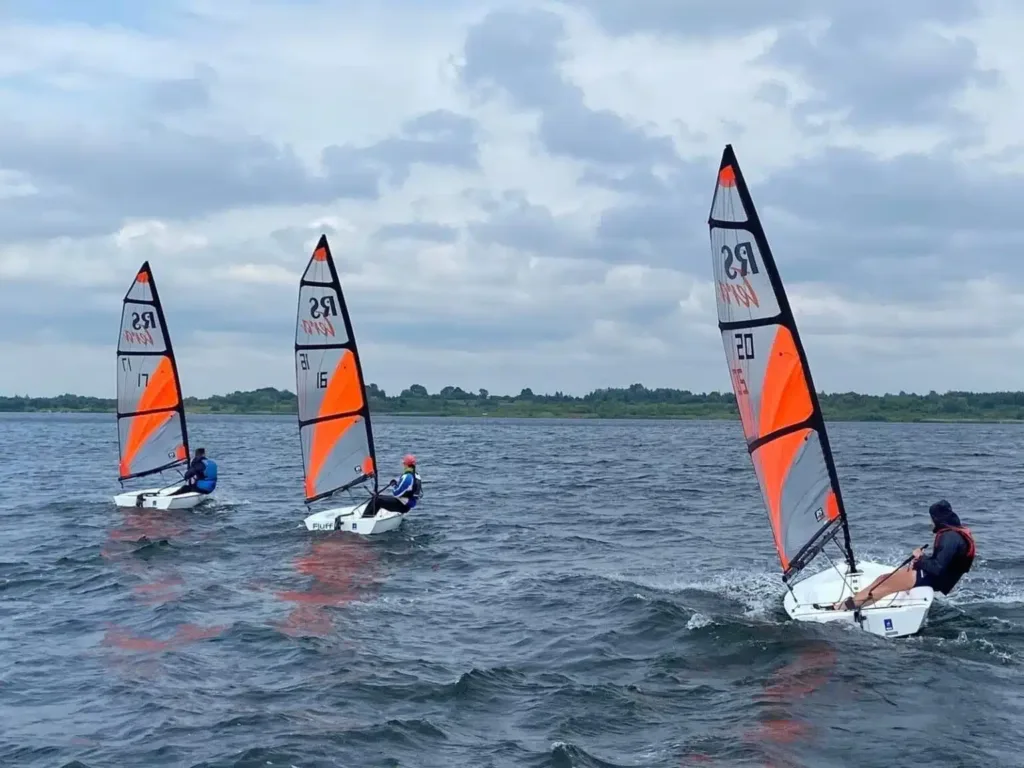 Три яхти з вітрилами на озері