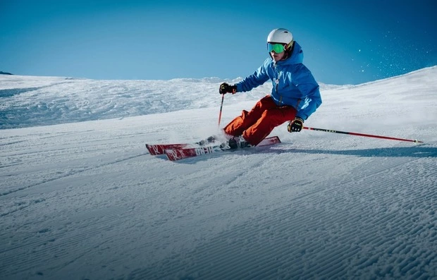 Лижник спускається засніженим схилом у горах