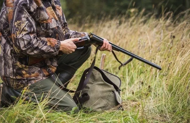 Мисливець заряджає рушницю на природі