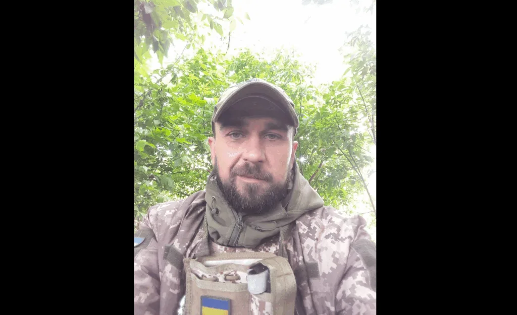 Військовий у камуфляжі серед зеленого лісу