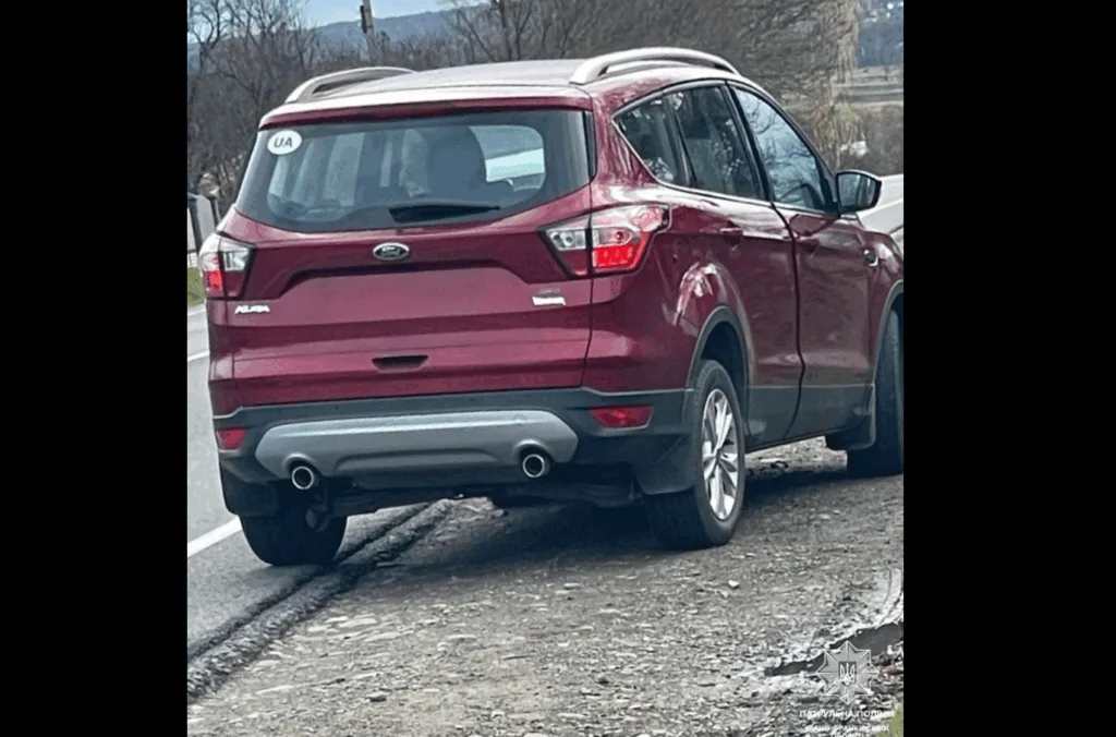 Червоний позашляховик припаркований біля узбіччя дороги