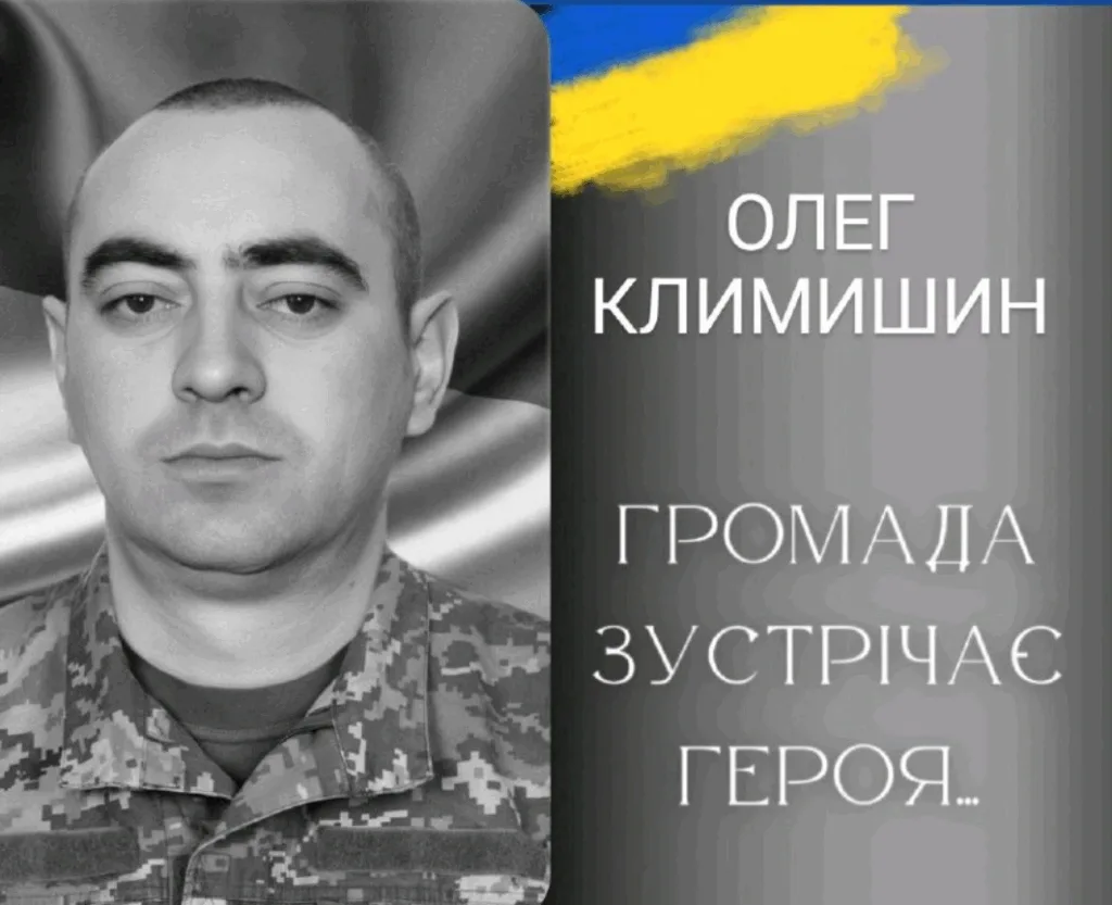 Військовий у формі перед прапором України