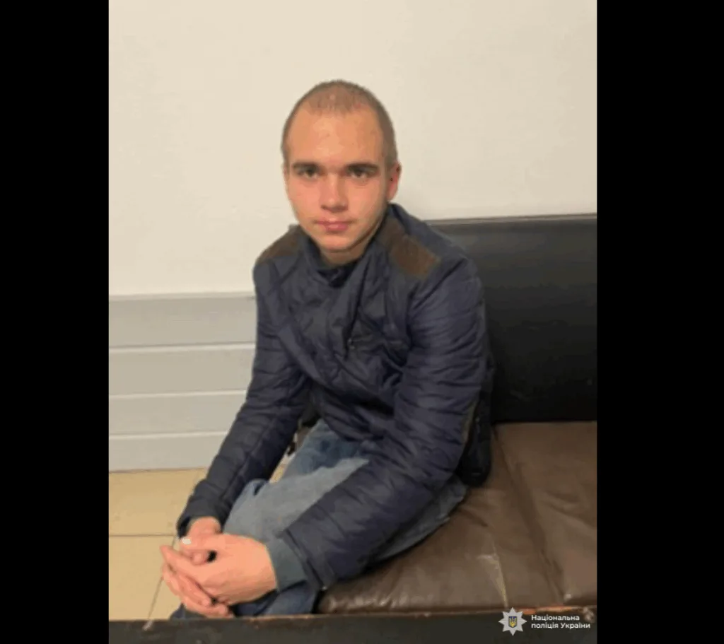 Молодий чоловік у темній куртці сидить на дивані