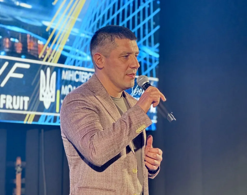 Чоловік виступає з мікрофоном на сцені