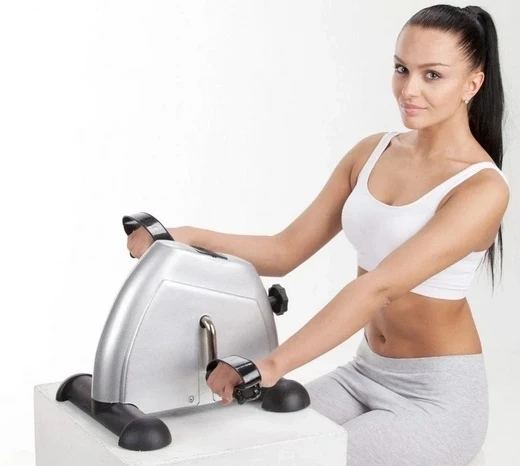 Жінка тренується на ручному міні-велотренажері