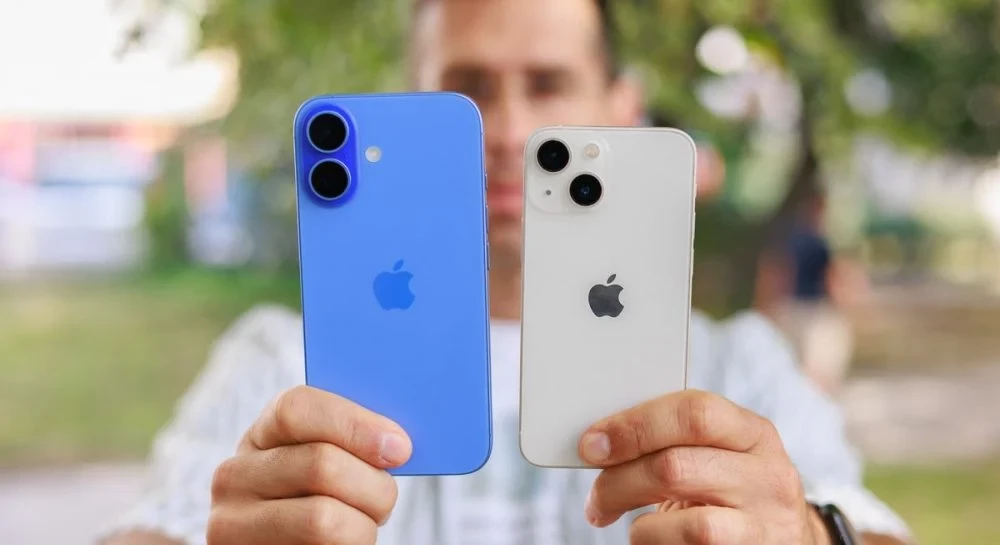 Людина тримає два смартфони iPhone синій і білий