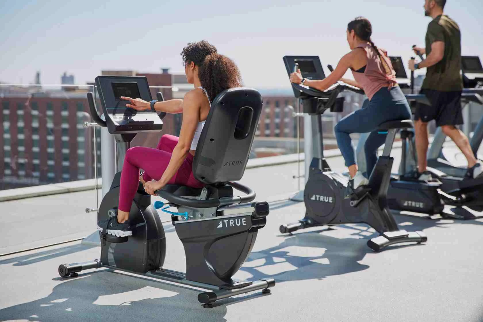 Люди тренуються на велотренажерах на даху