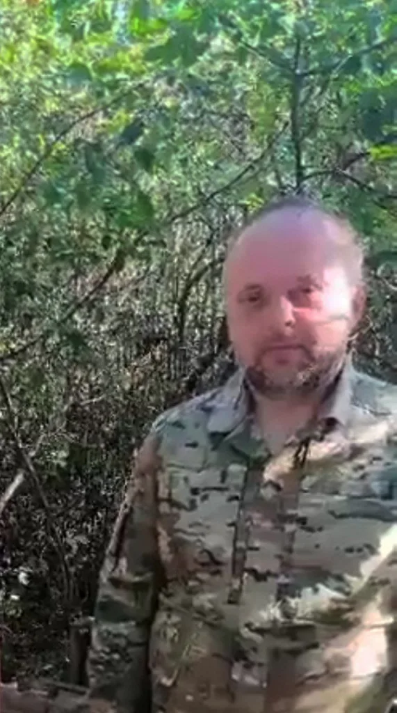 Військовий у камуфляжі стоїть серед дерев