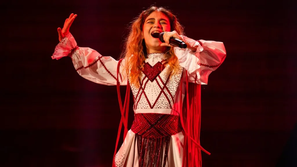 Дівчина співає на сцені у червоно-білому вбранні