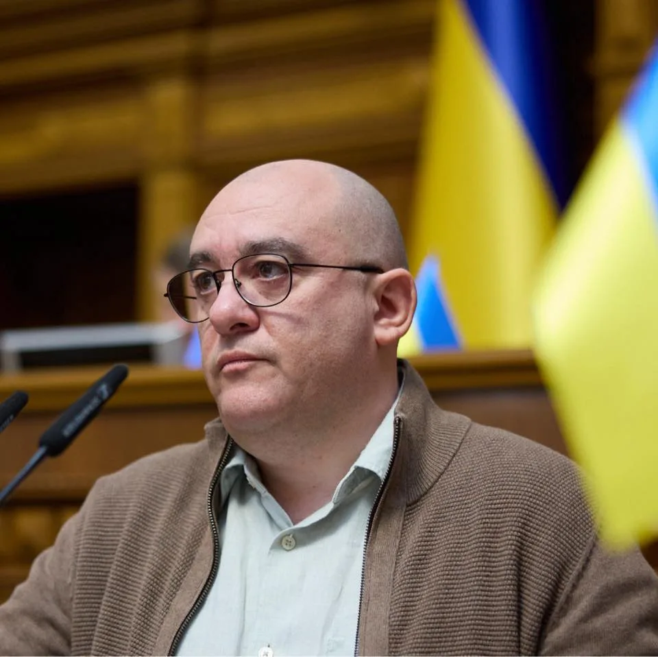 Чоловік виступає у будівлі з прапорами України