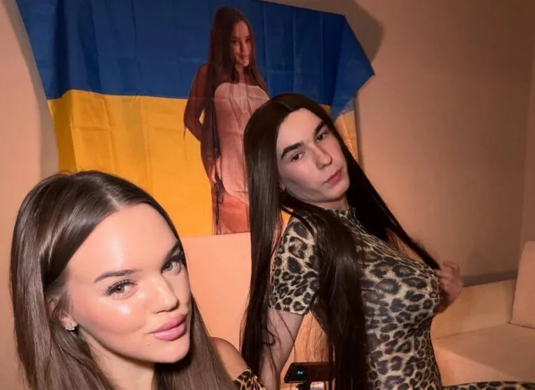 Дві людини позують перед прапором України