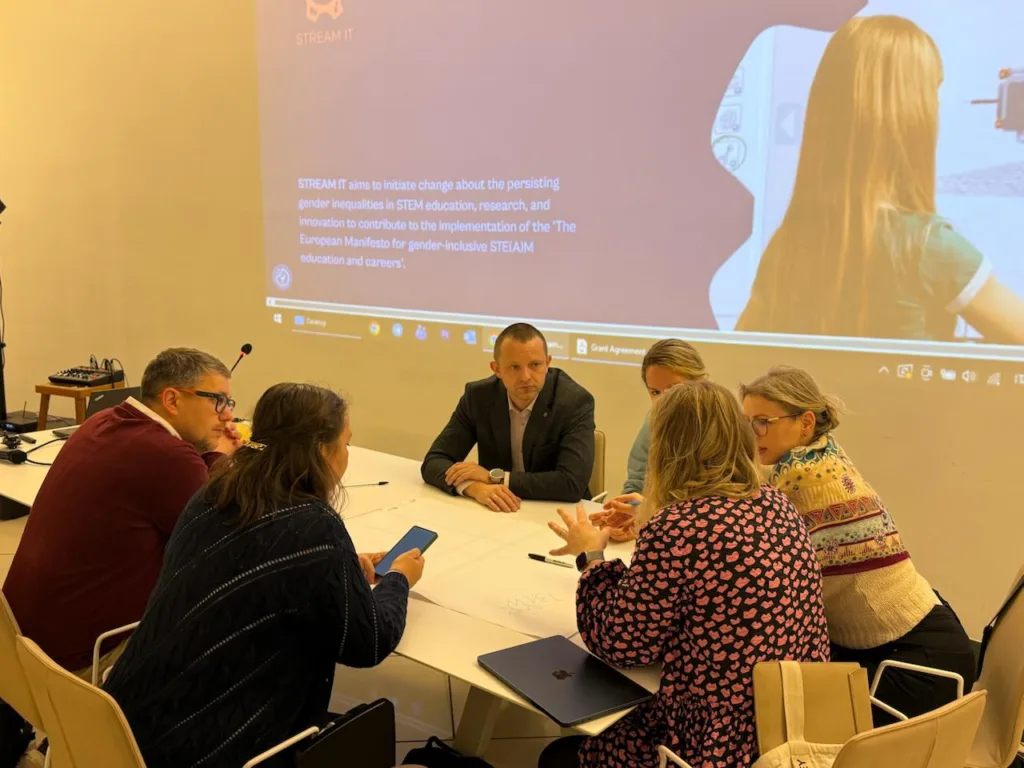 Група людей обговорює проєкт STREAM IT у кімнаті