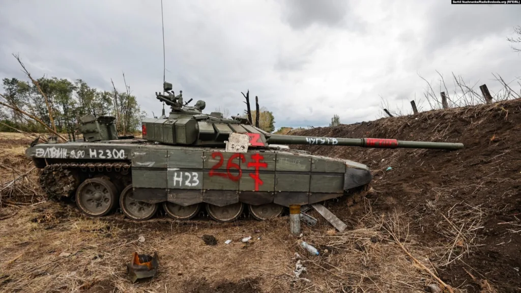 Пошкоджений військовий танк у полі