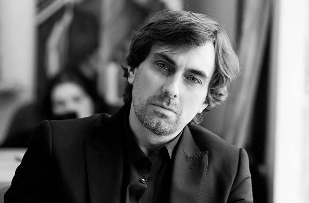 Чоловік у костюмі дивиться в камеру