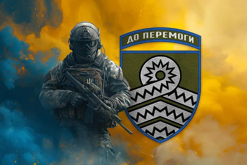 Український солдат перед емблемою з написом До перемоги