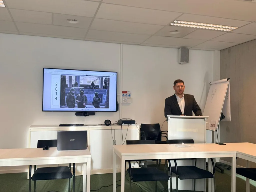 Чоловік проводить презентацію в офісі біля екрана