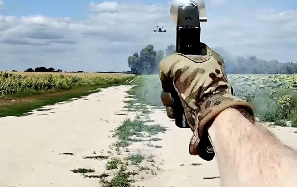 Людина стріляє по дрону в полі