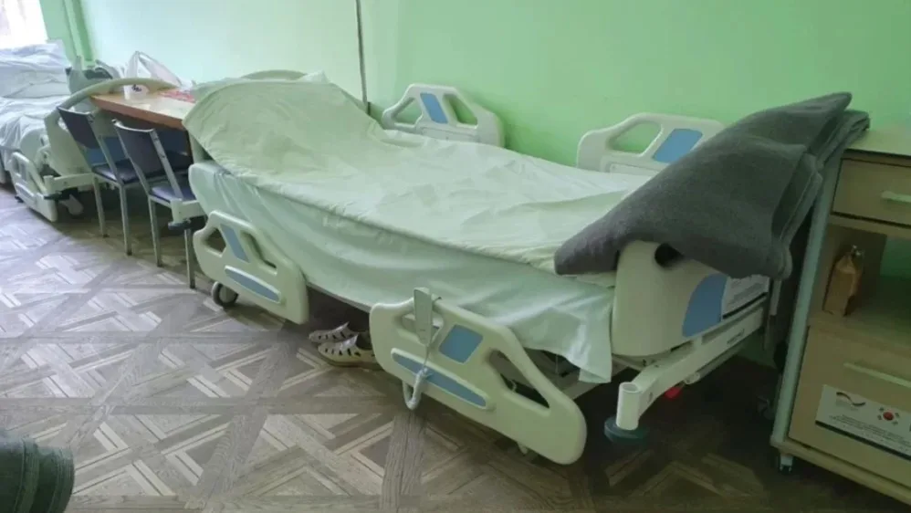 Палата лікарні з порожнім ліжком і зеленими стінами