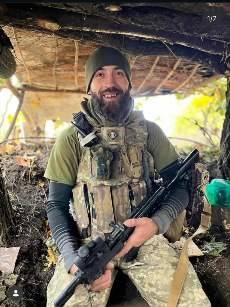 Український військовий у камуфляжі тримає зброю