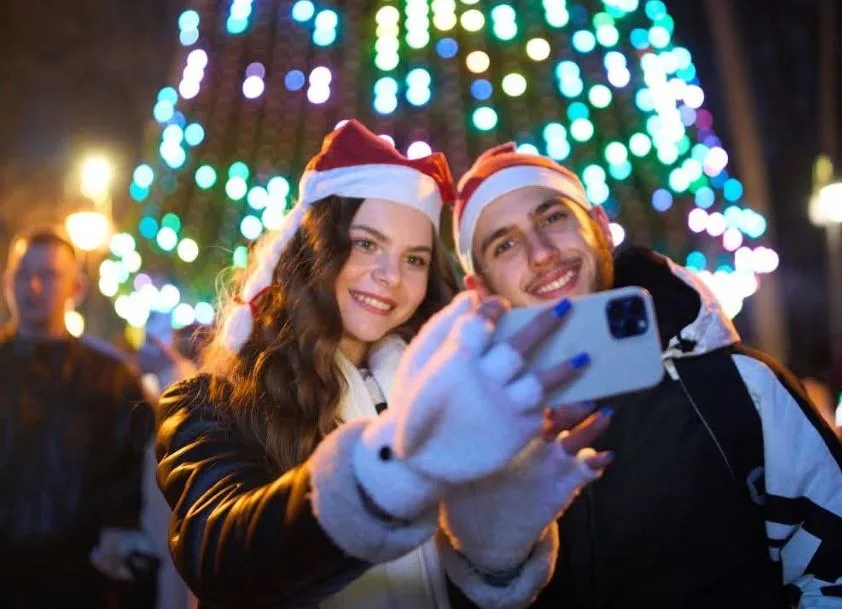 Пара робить селфі біля новорічної ялинки