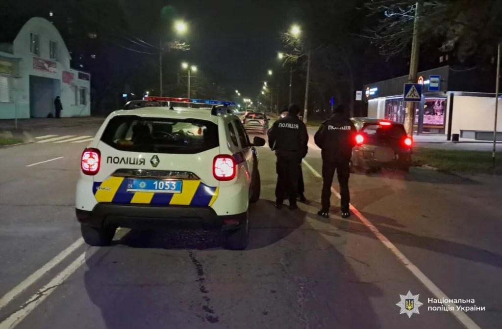 Поліцейські перевіряють автомобіль на нічній вулиці