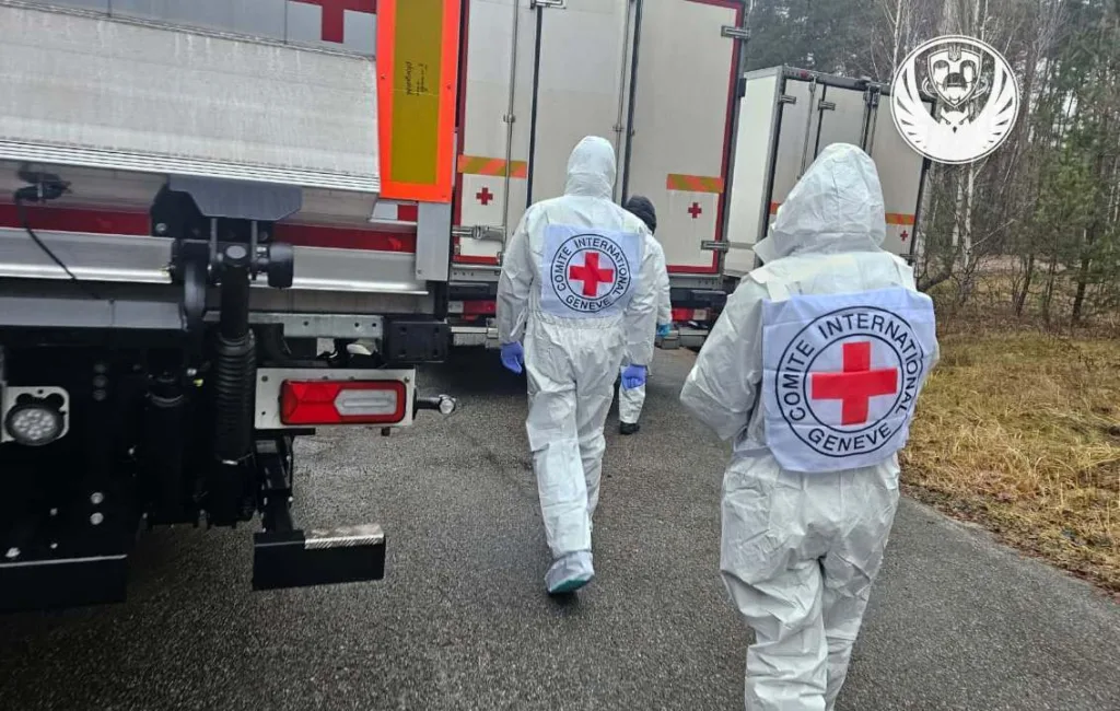 Працівники Червоного Хреста біля гуманітарних вантажівок