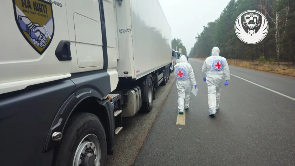 Медики Червоного Хреста йдуть поруч вантажівки