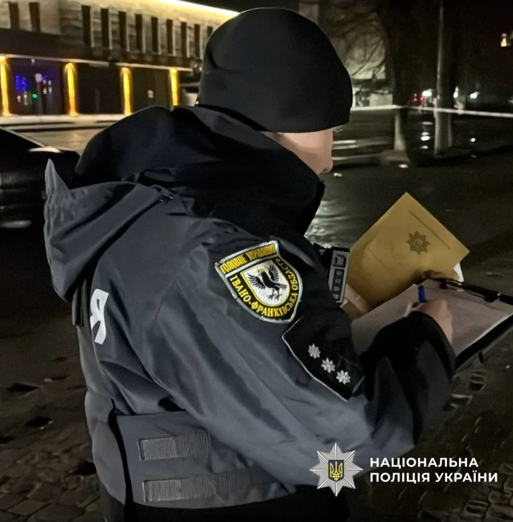 Поліцейський пише звіт на вулиці вночі