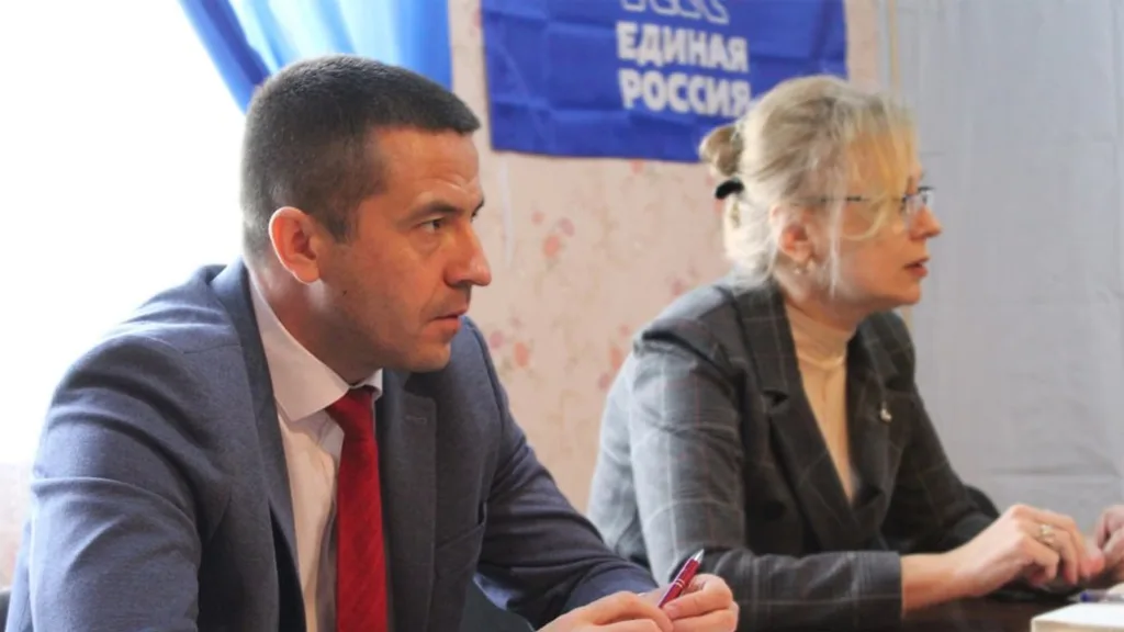 Двоє людей на зустрічі з прапором партії