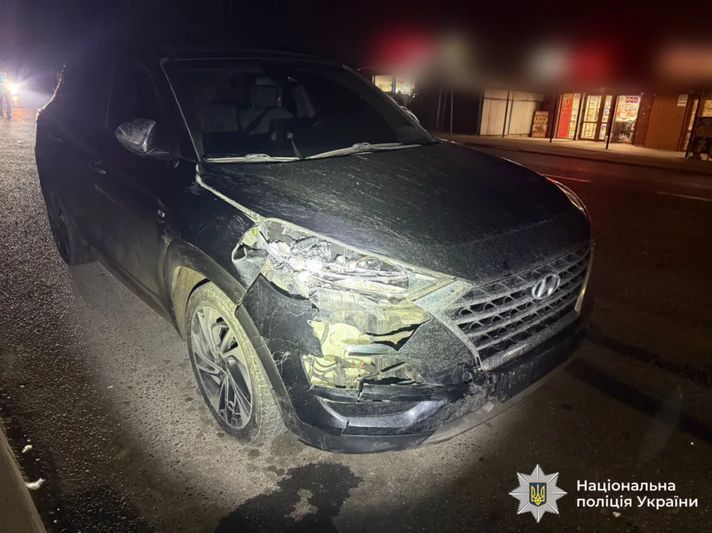 Пошкоджений чорний автомобіль після ДТП вночі