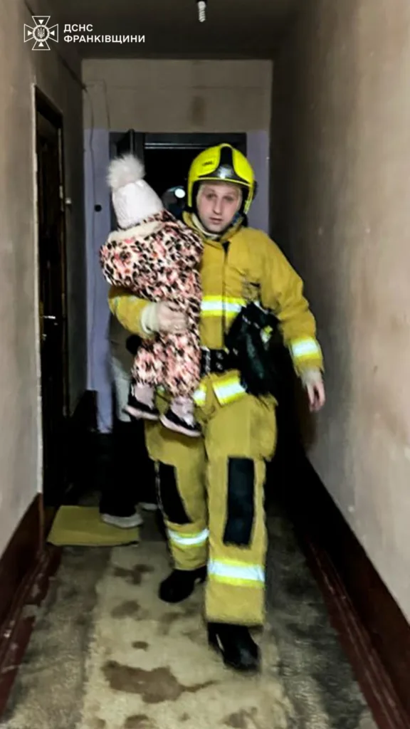 Рятувальник несе дитину з будівлі