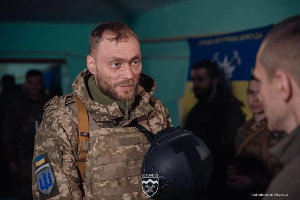 Український військовий у камуфляжі тримає шолом