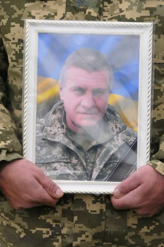 Військовий тримає портрет загиблого солдата