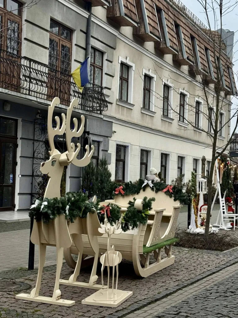 Різдвяні дерев'яні олені й санчата на вулиці